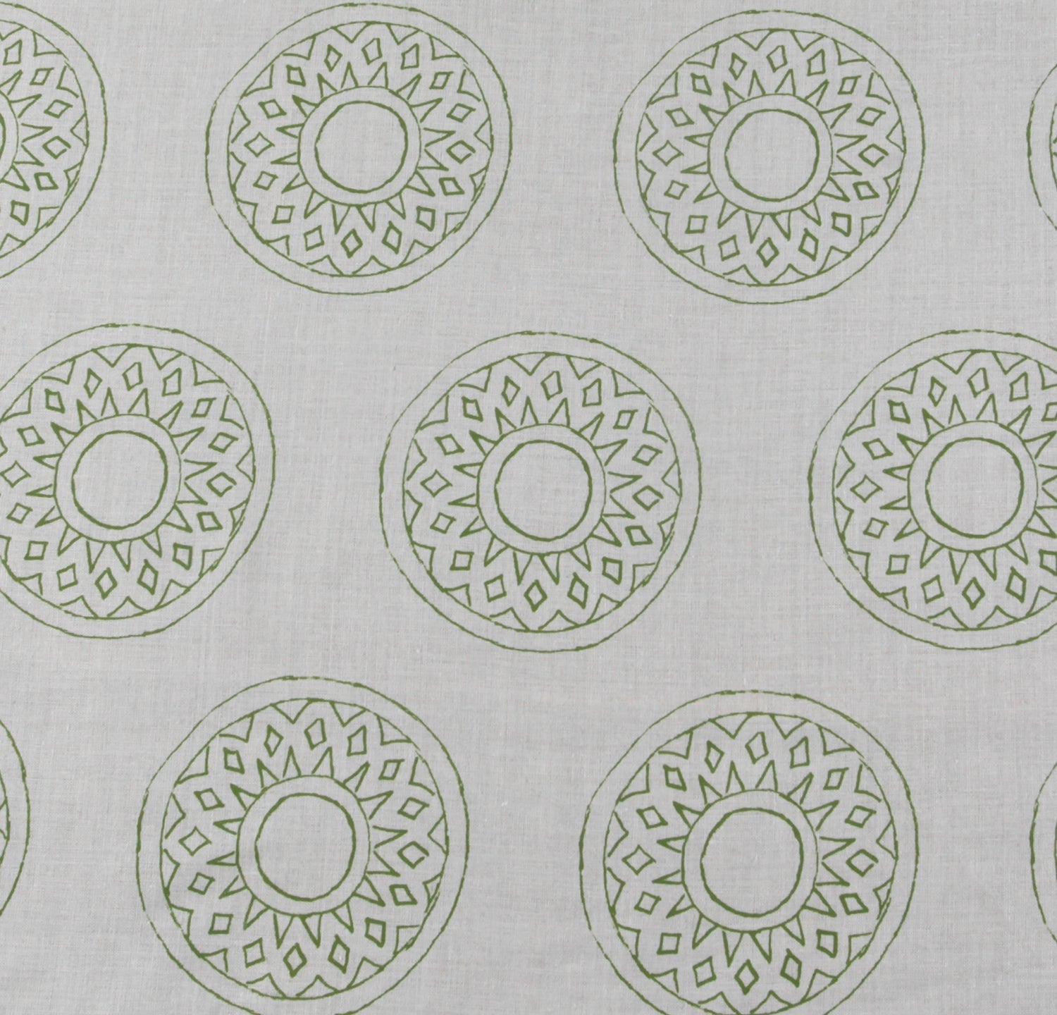 Detail of fabric in a repeating circular geometric print in green on a greige field.