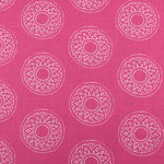 Detail of fabric in a repeating circular geometric print in white on a fuchsia field.