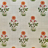 Detail of fabric in a large-scale marigold print in orange, red and green on a tan field.