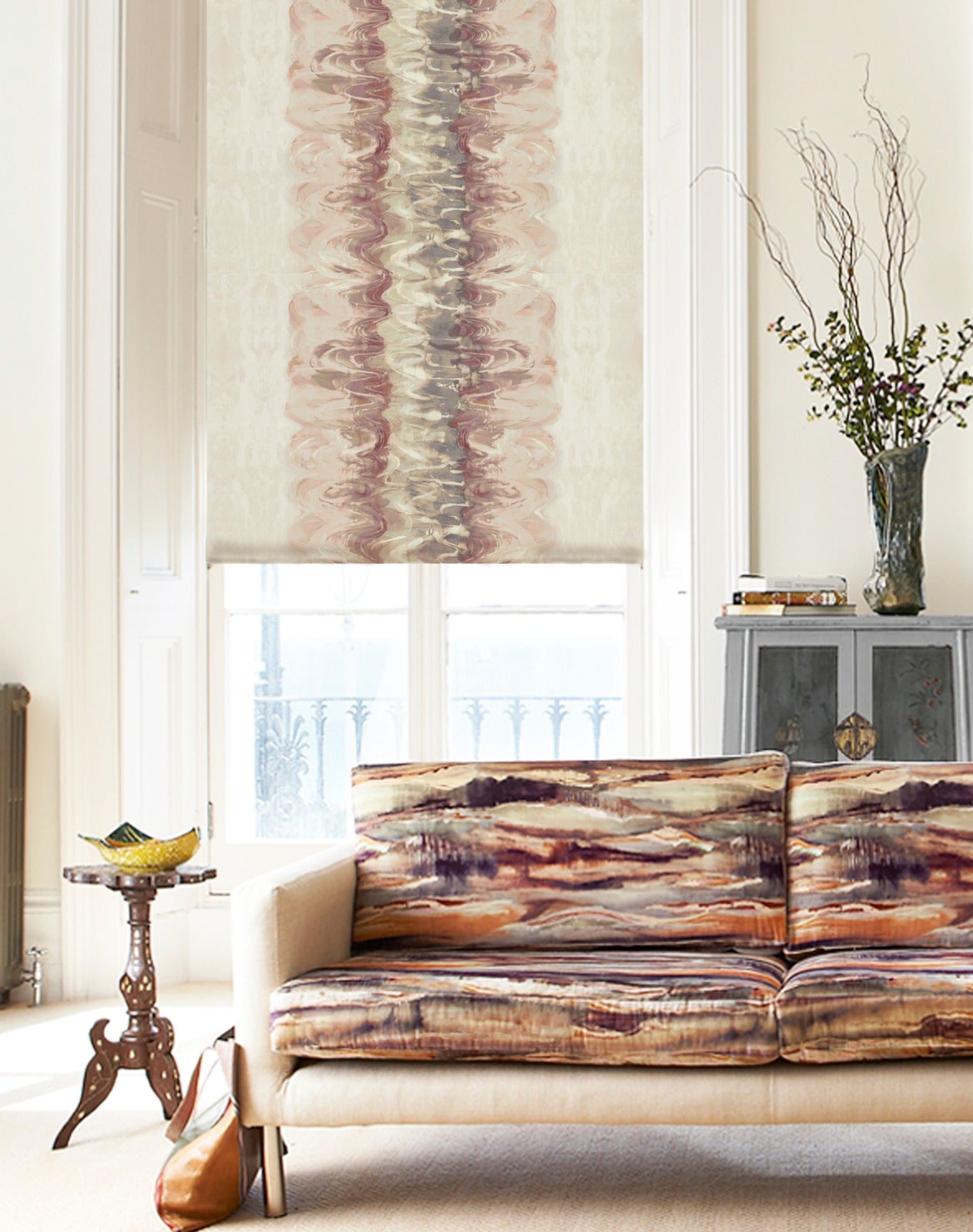 A modernist living space with a sofa and curtains both upholstered in abstract paint blot patterns.