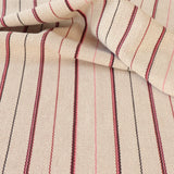 Detail of a draped hand-woven cotton striped fabric in cream brown, red and pink.