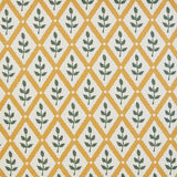 Detail of fabric in a lattice and leaf print in green and yellow on a white field.