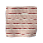 Square fabric swatch in an undulating stripe pattern in red and white on a pink field.