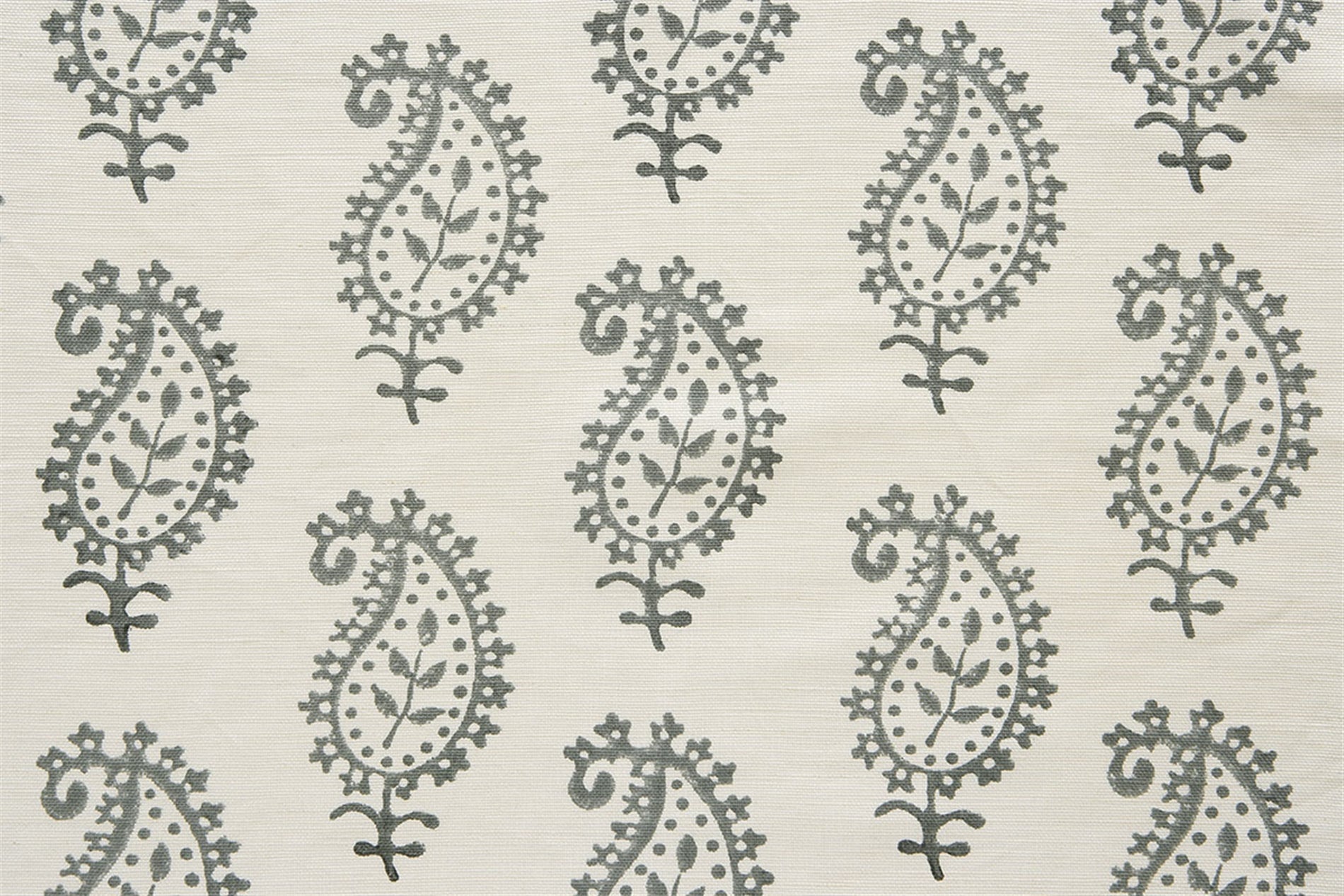 Detail of fabric in a repeating paisley print in gray on a cream field.