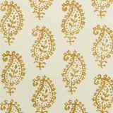 Detail of fabric in a repeating paisley print in mustard on a cream field.