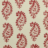 Detail of fabric in a repeating paisley print in red on a cream field.