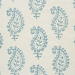 Detail of fabric in a repeating paisley print in light blue on a cream field.