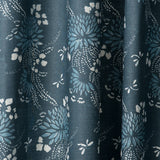 Draped printed fabric in a floral and dot pattern in blue and white on a navy field.