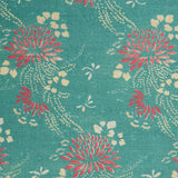 Detail of a linen fabric in a floral and dot pattern in red and beige on a turquoise field.