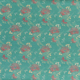 printed linen fabric in a floral and dot pattern in red and beige on a turquoise field.