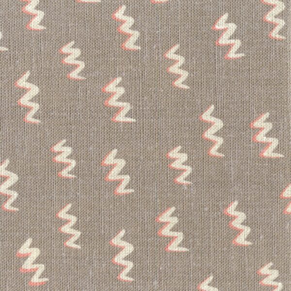 Fabric in a painterly zigzag pattern in pink and cream on a light brown field.
