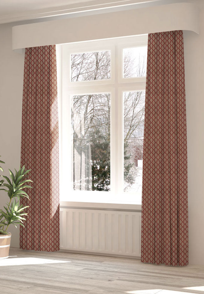 A large, sunny window with long curtains in a fern leaf print on a dark red field.