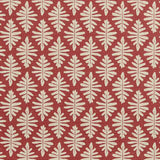 Detail of fabric in a repeating fern leaf print in cream on a dark red field.