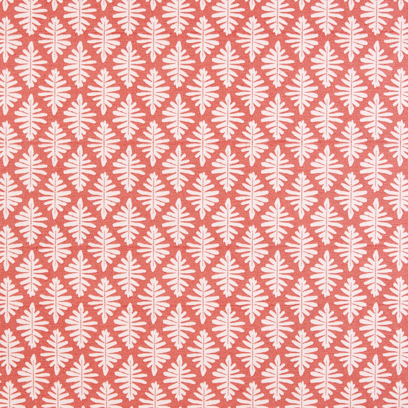 Detail of fabric in a repeating fern leaf print in white on a coral field.