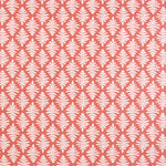 Detail of fabric in a repeating fern leaf print in white on a coral field.