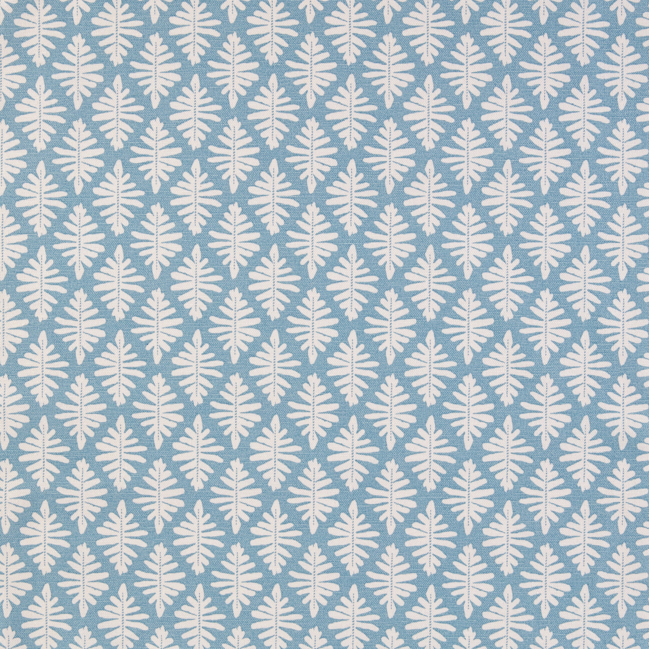 Detail of fabric in a repeating fern leaf print in white on a light blue field.