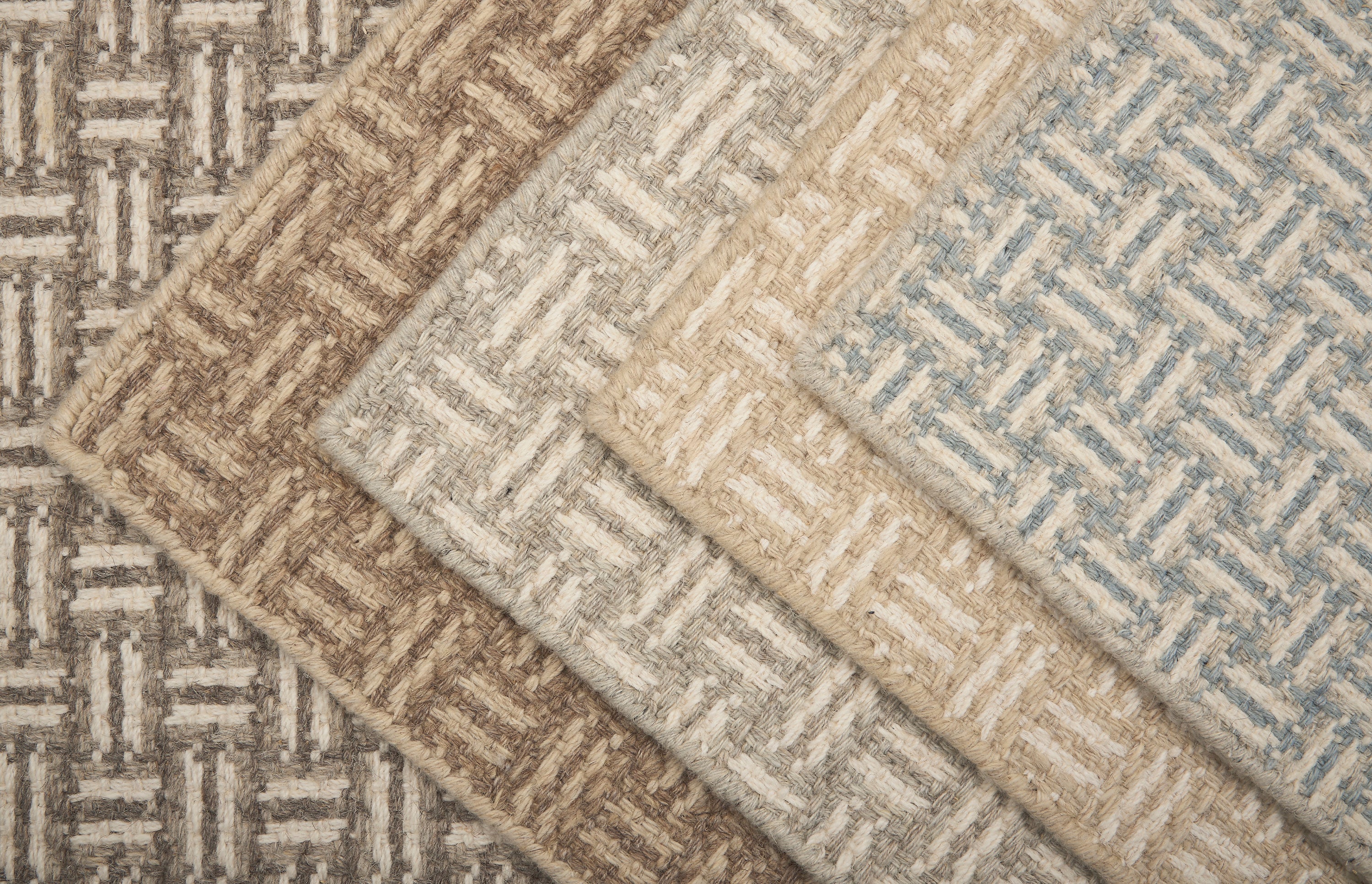 Collection of textured rugs with geometric patterns in neutral colors.