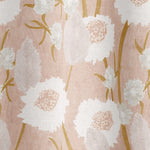 Draped fabric in a playful floral print in shades of pink, white and tan on a light pink field.