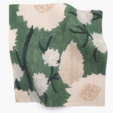 Square fabric swatch in a playful floral print in shades of white, pink and green on a light green field.