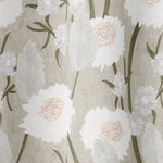 Draped fabric in a playful floral print in shades of white, olive and gray on a cream field.