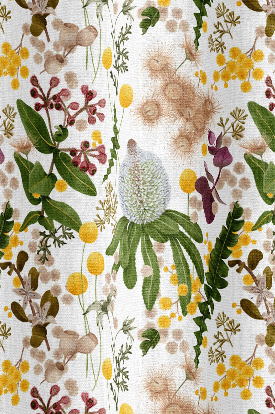 Draped fabric in a large-scale botanical print in shades of pink, yellow and green on a cream field.