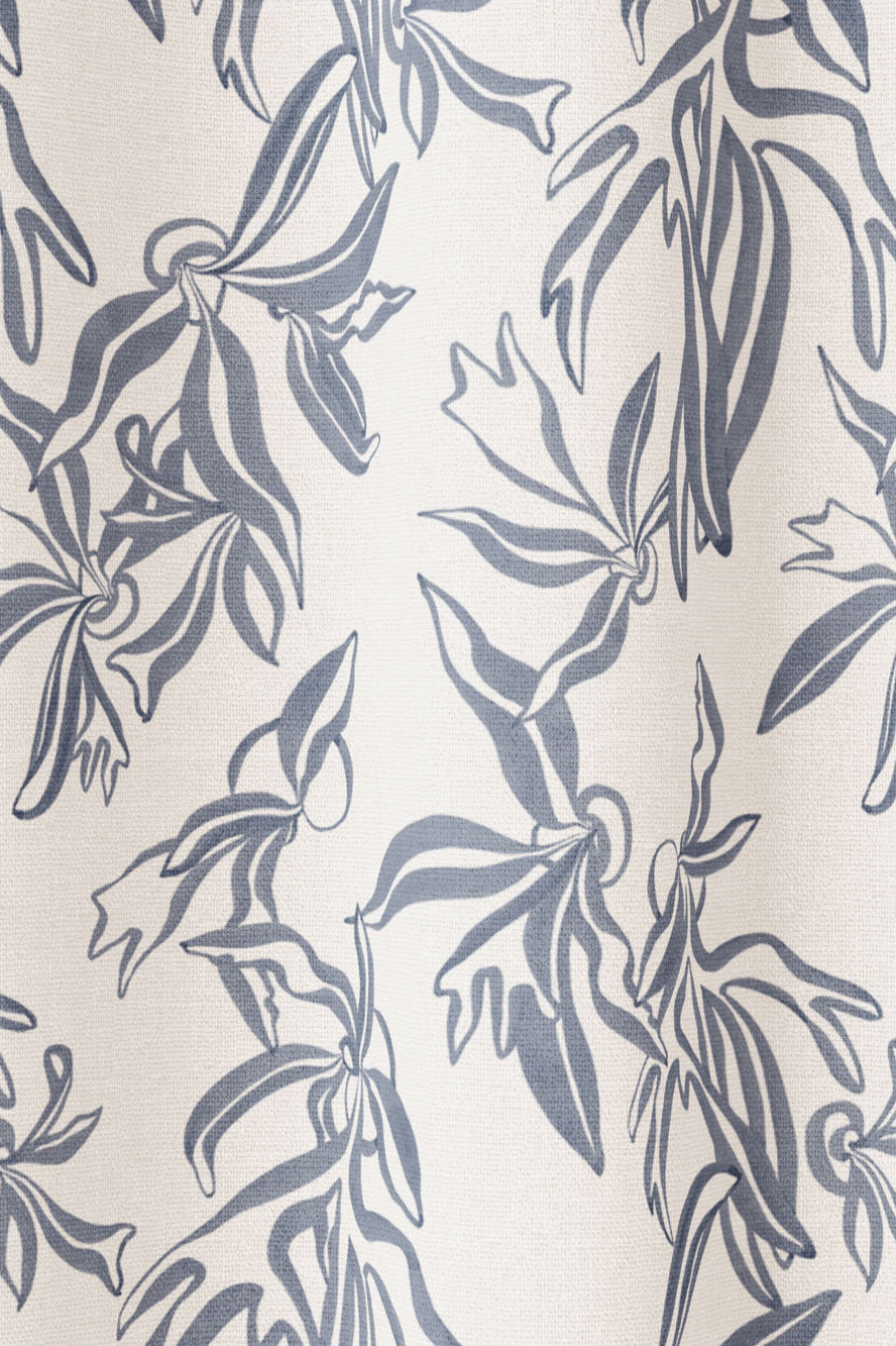 Draped fabric in a painterly leaf print in blue-gray on a cream field.