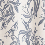 Draped fabric in a painterly leaf print in blue-gray on a cream field.