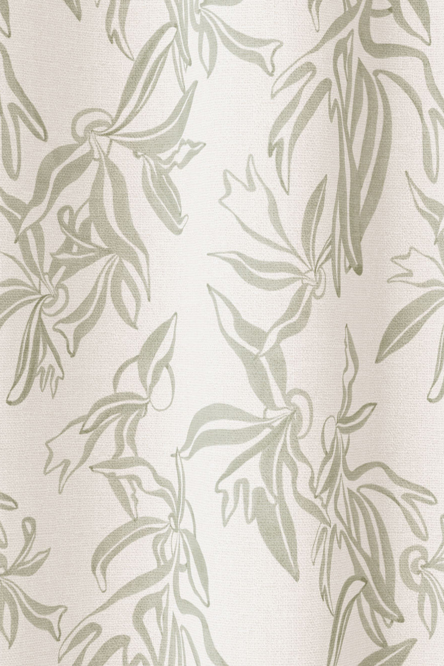 Draped fabric in a painterly leaf print in greige on a cream field.