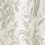 Draped fabric in a painterly leaf print in greige on a cream field.