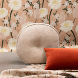 A tableau of arranged throw pillows and fabric yardage in tan, red and various floral prints.