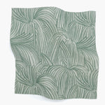 Square fabric swatch in a textural painted print in sage on a cream field.