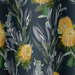 Draped fabric in a photorealistic floral print in shades of yellow, white and green on a navy field.