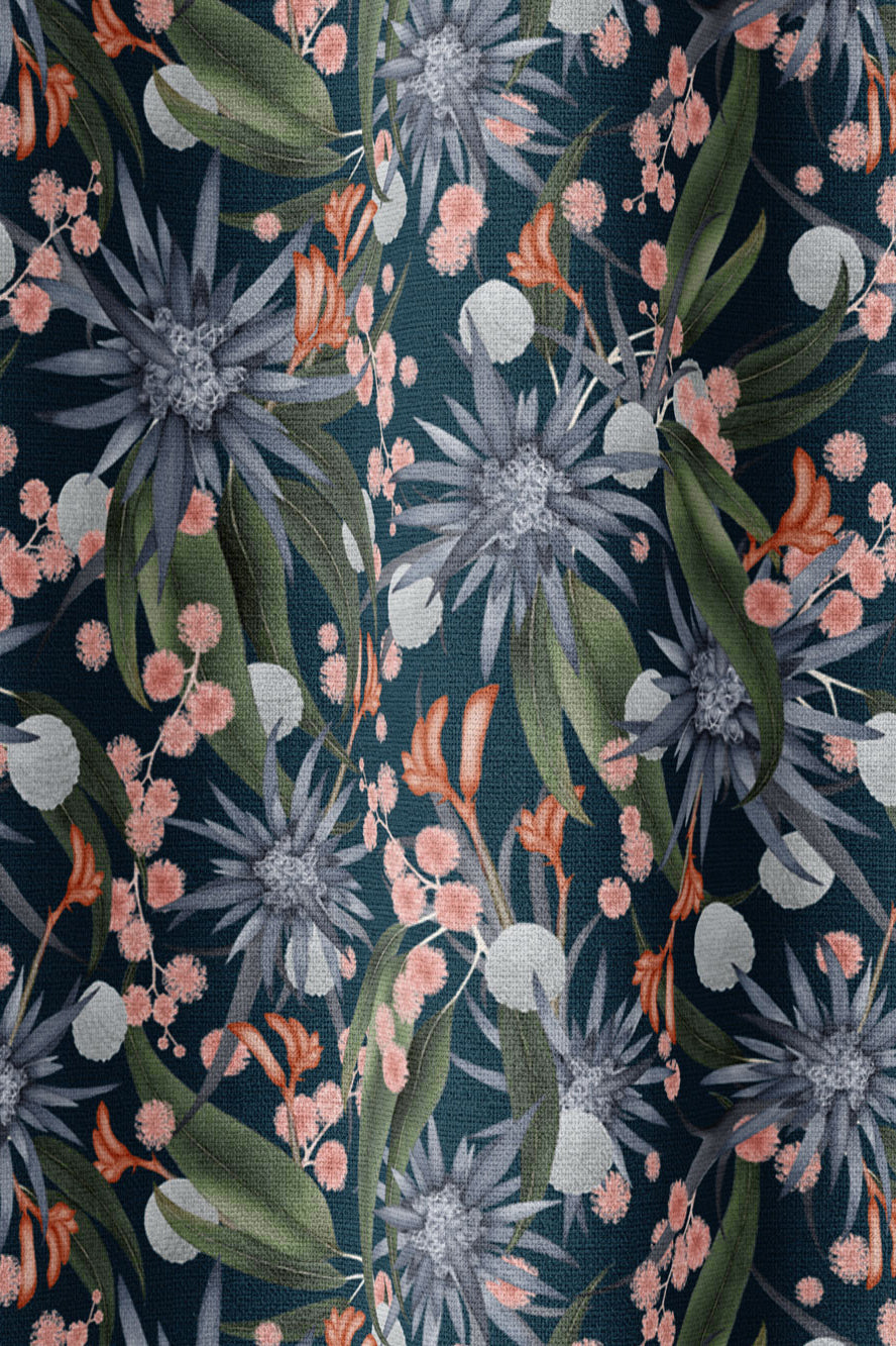 Draped fabric in a large-scale botanical print in shades of blue, green and coral on a navy field.