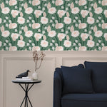 A couch and end table stand in front of a wall papered in a playful floral print in white, pink and green.