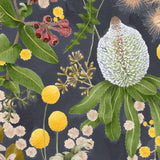 Detail of wallpaper in a large-scale botanical print in shades of pink, yellow and green on a navy field.