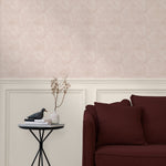 Living room with a wall papered in a textural painted print in blush on a cream field.