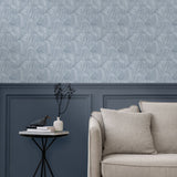 Living room with a wall papered in a textural painted print in blue on a cream field.