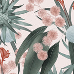 Detail of wallpaper in a large-scale botanical print in shades of blue, turquoise and pink on a light pink field.