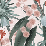 Detail of wallpaper in a large-scale botanical print in shades of blue, turquoise and pink on a light pink field.