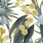 Detail of wallpaper in a large-scale botanical print in shades of blue, turquoise and yellow on a cream field.