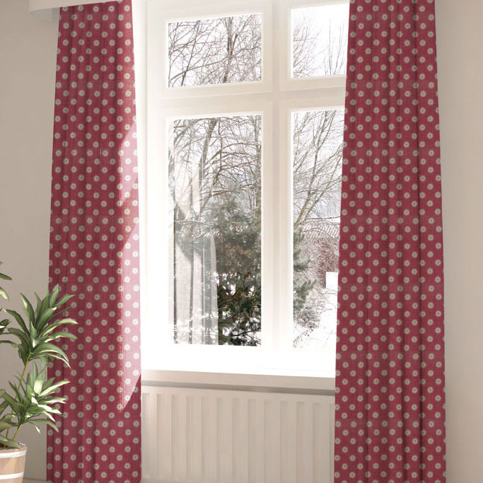 A large, sunny window with long curtains in a playful dot print on a maroon field.