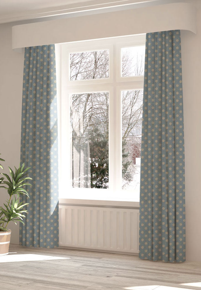 A large, sunny window with long curtains in a playful dot print on a light blue field.