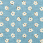 Detail of fabric in a playful dot print in cream and charcoal on a light blue field.