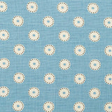 Detail of fabric in a playful dot print in cream and charcoal on a light blue field.