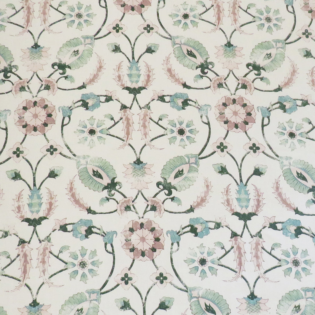 Detail of fabric in a floral paisley print in shades of pink and green on a cream field.