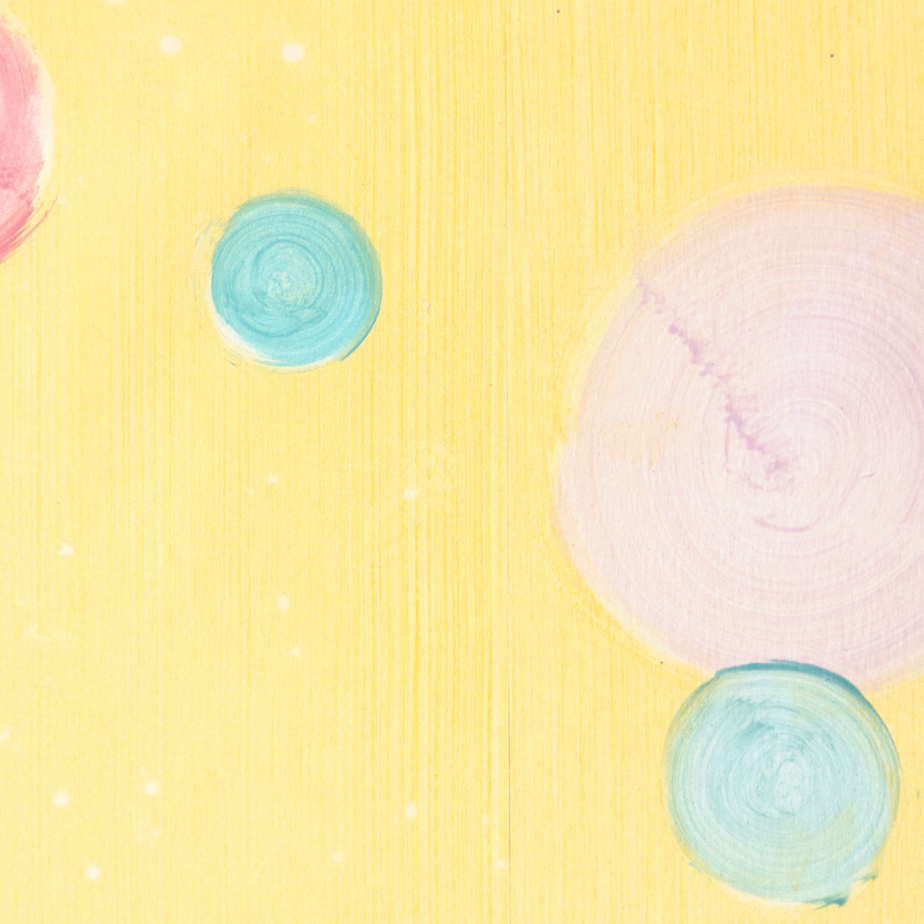 Detail of a wallpaper in a paint splatter print in metallic multicolor pastels on a yellow field.