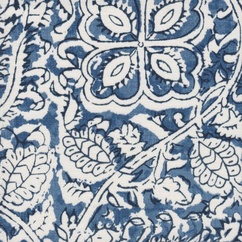 Detail of fabric in a painterly floral paisley in shades of blue and navy on a white field.