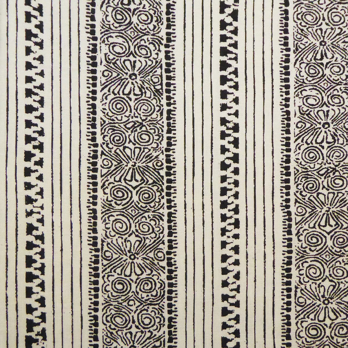 Detail of fabric in a botanical stripe print in black on a cream field.