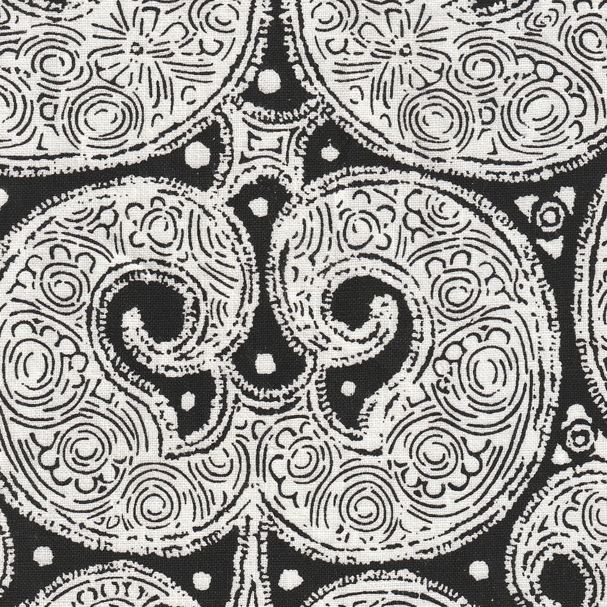 Detail of fabric in a paisley print in white on a black field.