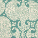 Detail of fabric in a paisley print in cream on a turquoise field.